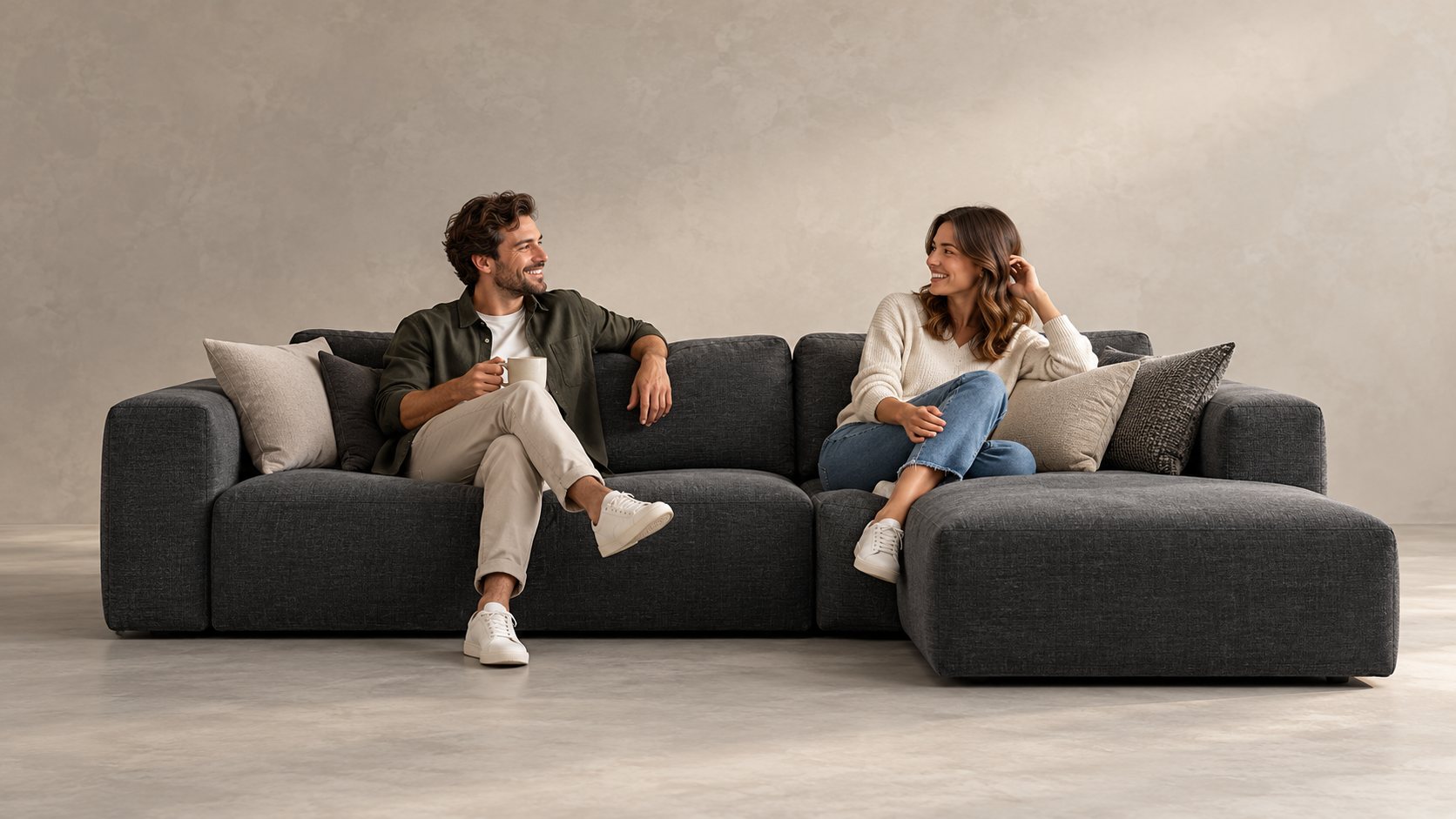 Two friends relaxing and chatting on a charcoal sectional sofa